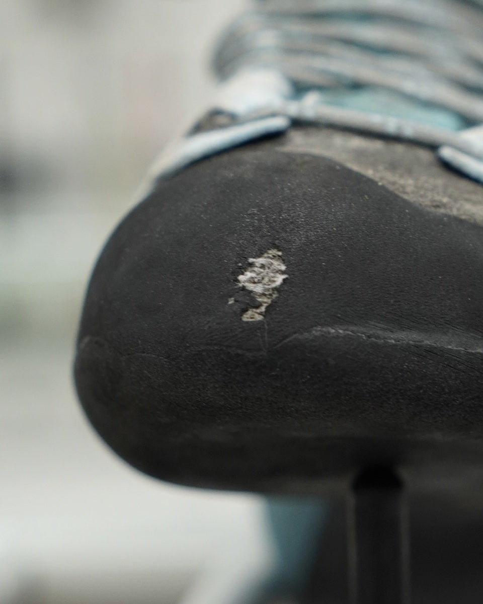 Close-up of a worn-out black shoe sole with visible scuff marks.