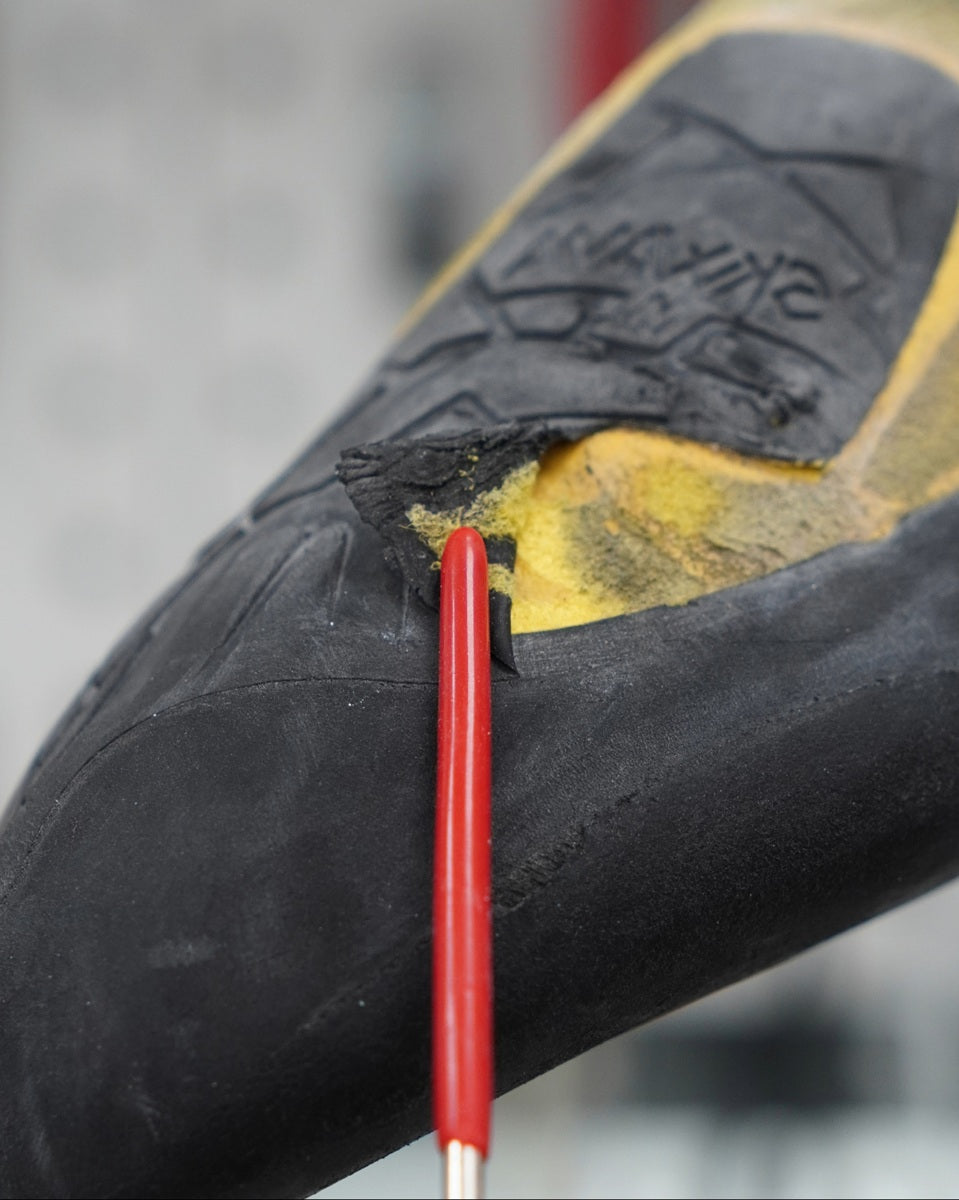 Close-up of a shoe sole with a red tool on a blurred background