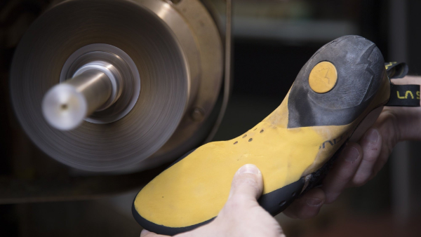 Person polishing a shoe sole with a machine
